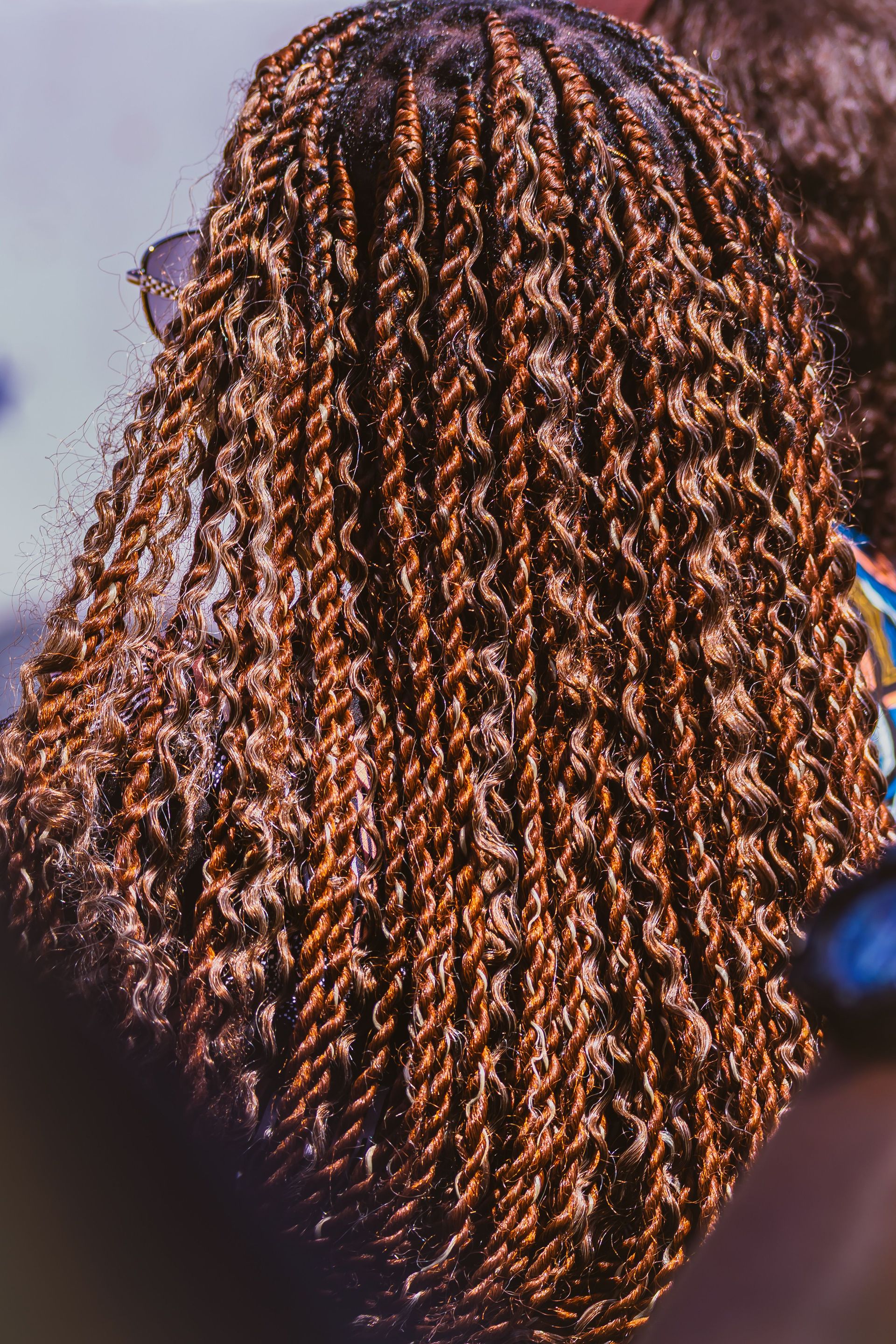 Detailed view of a woman's textured braids, showcasing intricate hair styling.